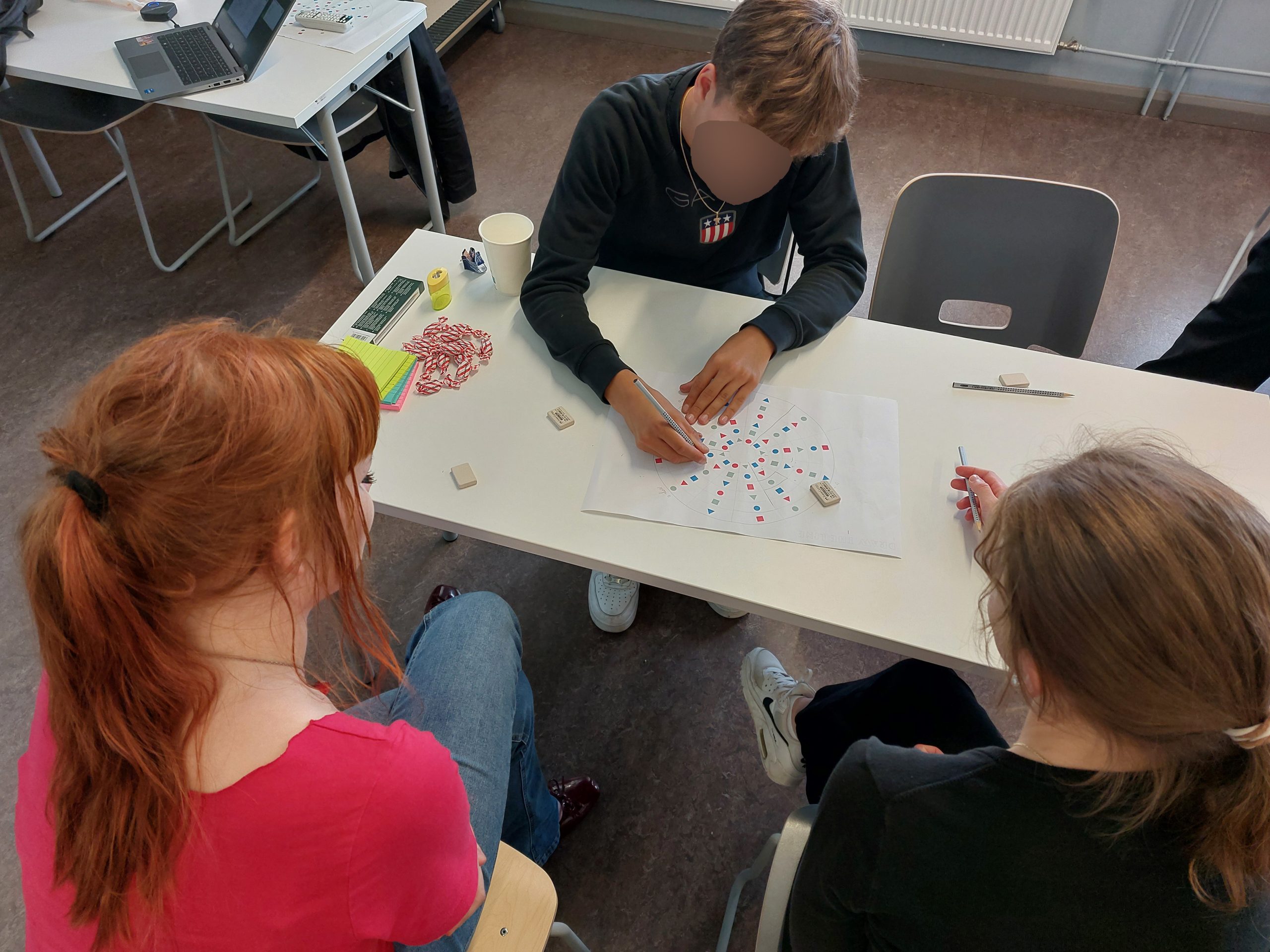 draw-the-line-a-participant-drawing-on-game-board Young people playing draw the line.